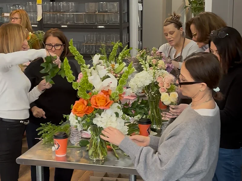 a group of friends creating floral arrangements in our floral workshop.